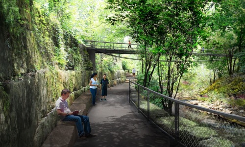people walking in a park with trees and a bridge