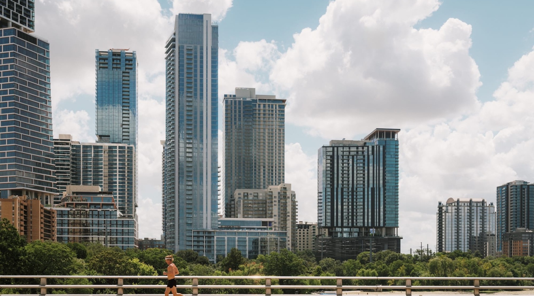 city skyline with a man running on a bridge