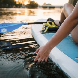 a woman on a kayak with her hand in the water